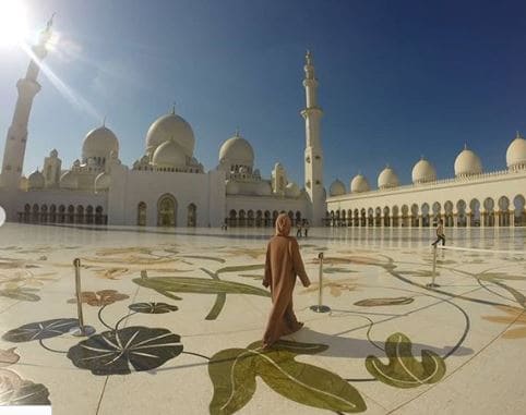 Mulher de costas caminhando na Grande Mesquita em Abu Dhabi