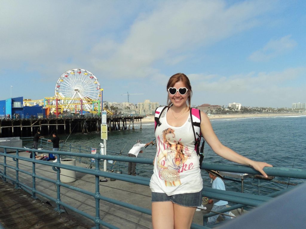 Foto no pier de Santa Monica, com o parque de diversões ao fundo, em LA