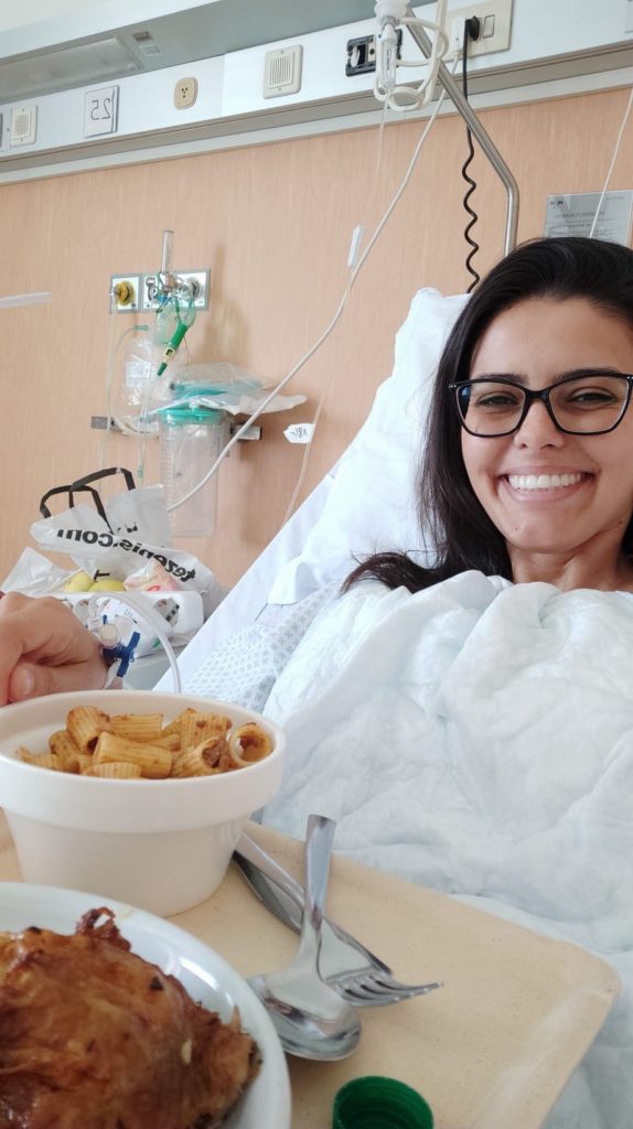Jéssica no hospital na Itália, comendo um pote de macarrão